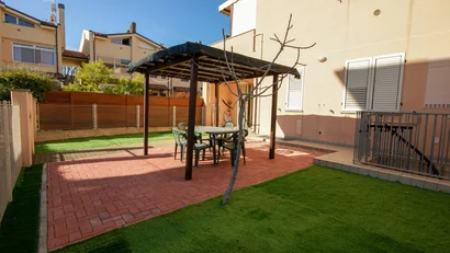 Giardino con tavolo, sedie e gazebo in un cortile di casa