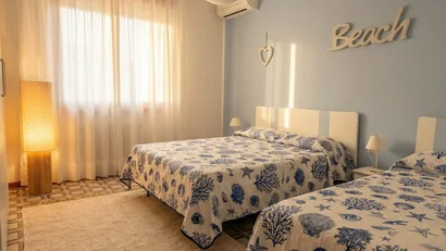 Camera da letto con due letti e decorazioni a tema mare blu e bianco