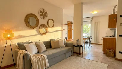 Soggiorno luminoso con divano, lampada e decorazioni a parete