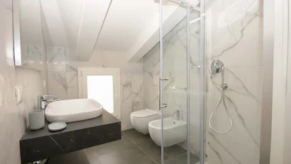 Bagno moderno con doccia, lavabo, bidet e WC in piastrelle di marmo