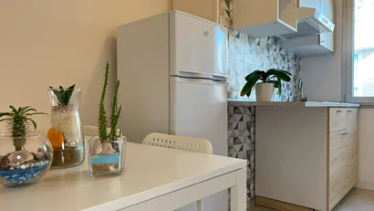 Cucina compatta con frigorifero bianco e piante su tavolo