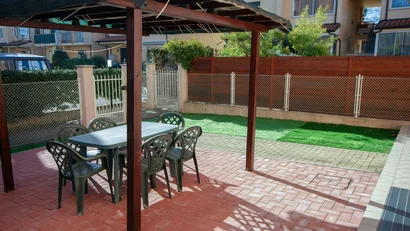 Tavolo e sedie nel giardino con pergola e recinzione