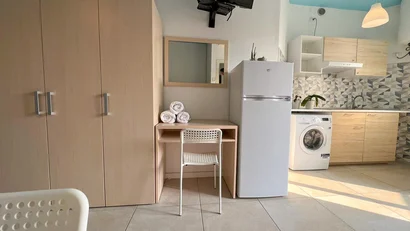 Interno di cucina moderna con frigorifero, lavatrice e mobili in legno chiaro