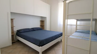 Camera con letto matrimoniale e letto a castello in una stanza luminosa